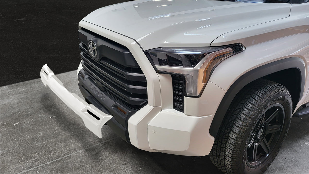 Gloss white 2022 Toyota Tundra Fog Lamp Bezel Overlay lifted off the vehicle, illustrating the installation area and potential appearance post-installation