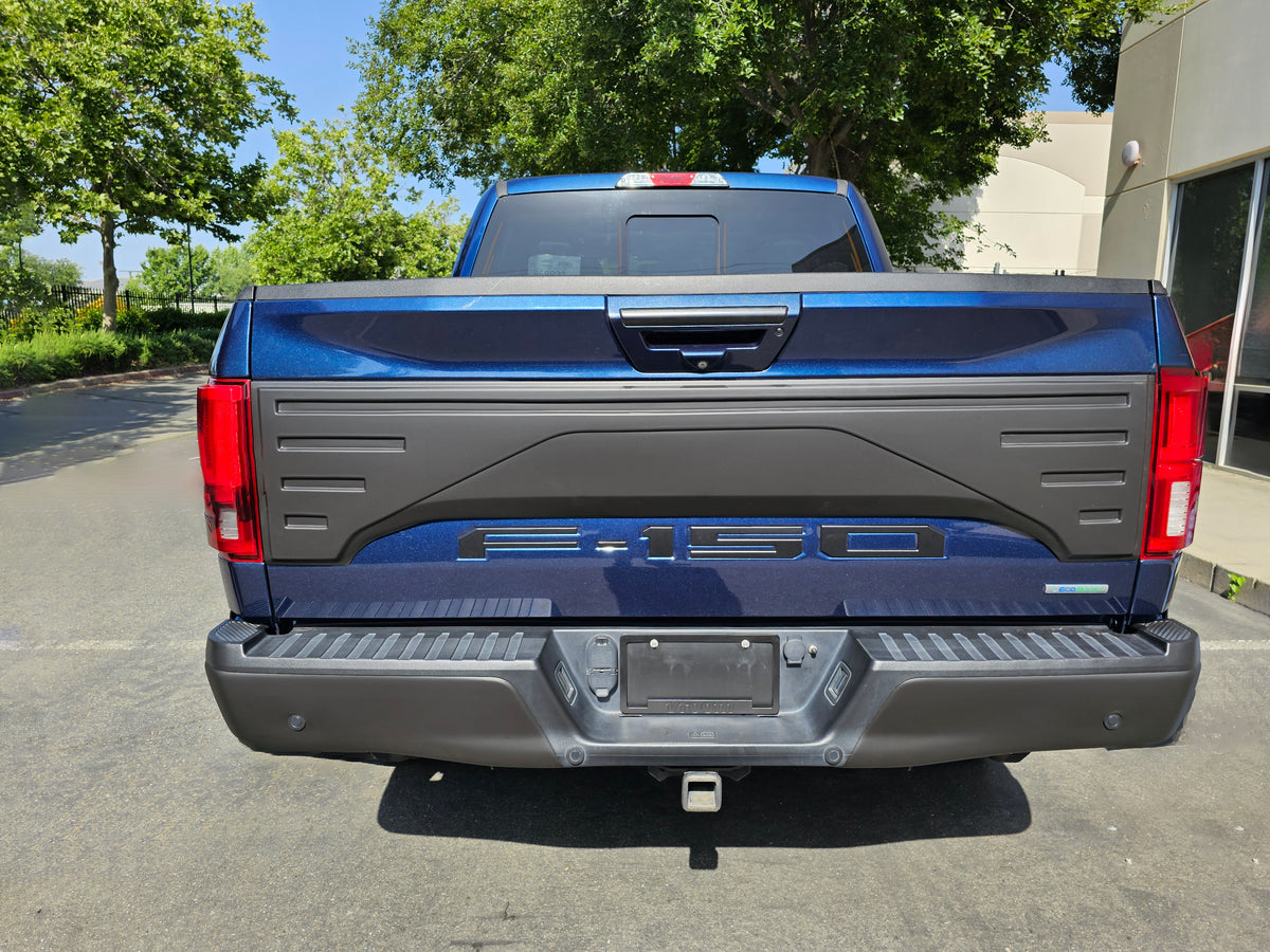 Tailgate Applique installed on a 2015-2020 F150, showcasing the enhanced look to the tailgate, with the truck positioned parked outside a business
