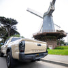 Toyota Tacoma with matte black bumpershellz parked outside windmill, ready for adventure