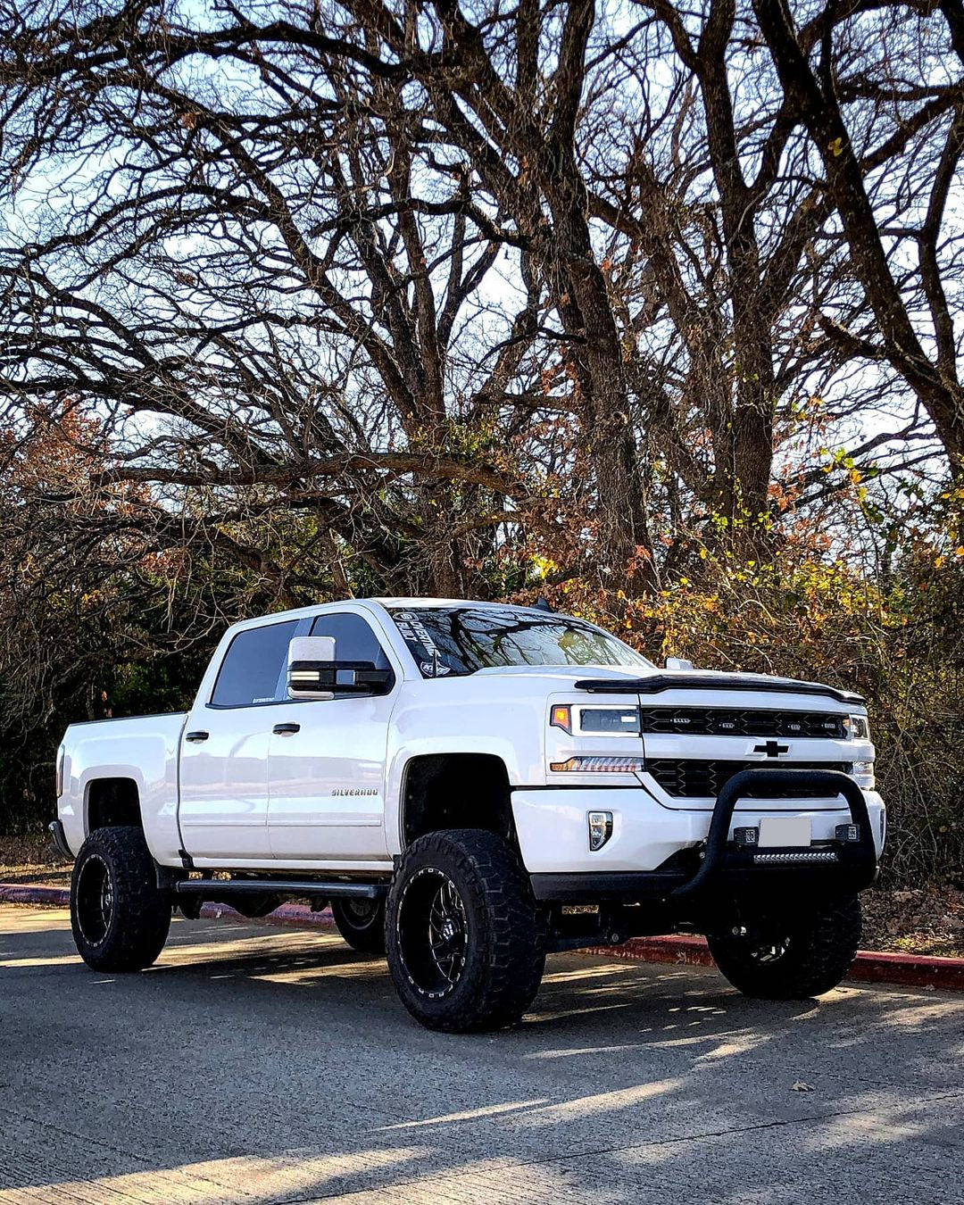 showing off BumperShellz 2016-2018 Chevy Silverado 1500 - Front BUMPERSHELLZ™ installed on a gloss white truck