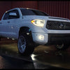 Super White II Toyota Tundra at night with headlights and fog lamps on sporting BumperShellz