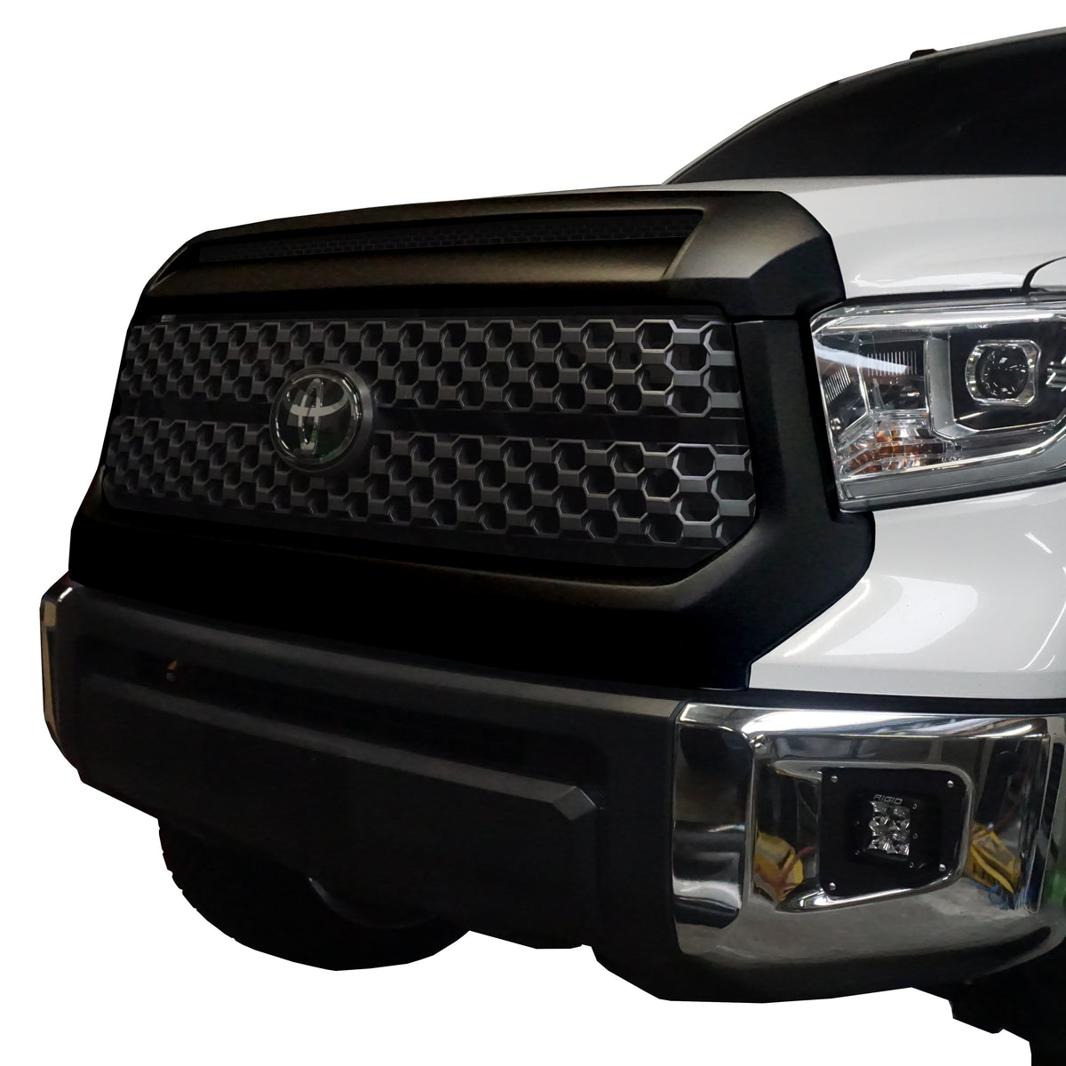  A 45-degree angled front and side view of a 2014-2021 Toyota Tundra featuring Paintable ABS BumperShellz overlays installed on the grille surround and hood bulge.