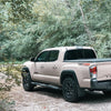 Textured TPO BumperShellz installed on a 2016-2023 Toyota Tacoma, parked in the woods