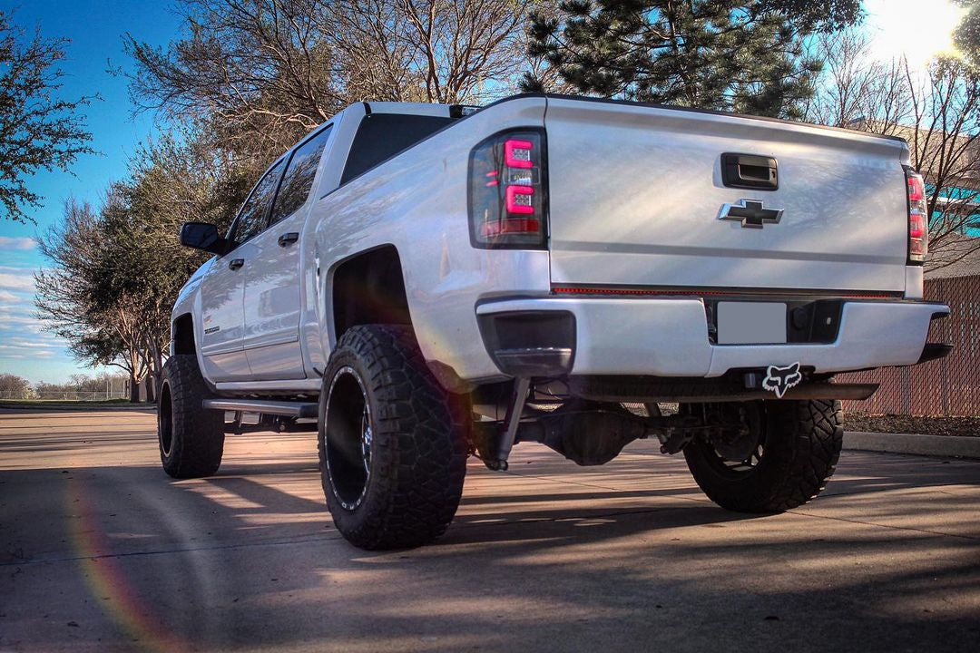 Olympic White rear bumpershellz installed on a 2018 Chevy Silverado, parked outside with a fresh black out kit