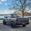 Dual Exhaust rear bumper covers installed on a RAM truck, parked outside of a lake