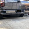 Gloss Black rear bumper covers installed on a 2014-2018 Chevy Silverado parked in a garage, showing off a fresh chrome delete look