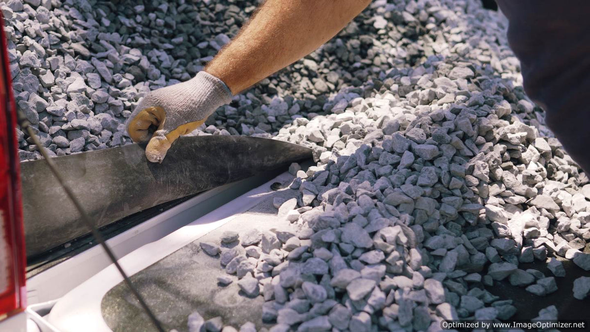 Visual proof of the GapShield’s effectiveness, with hands lifting the cover to show a clean separation between the truck bed and tailgate, devoid of rocks or debris.