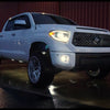 Super White II 2014-2021 Toyota Tundra at night with headlights and fog lamps on sporting BumperShellz Hood Bulge and Grille Surround overlays